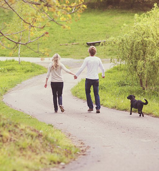 Young beautiful couple taking a walk in green park